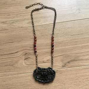 Asian pendent necklace with red colored stones.
